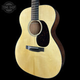 Acoustic guitar with a visible brand logo on a black background