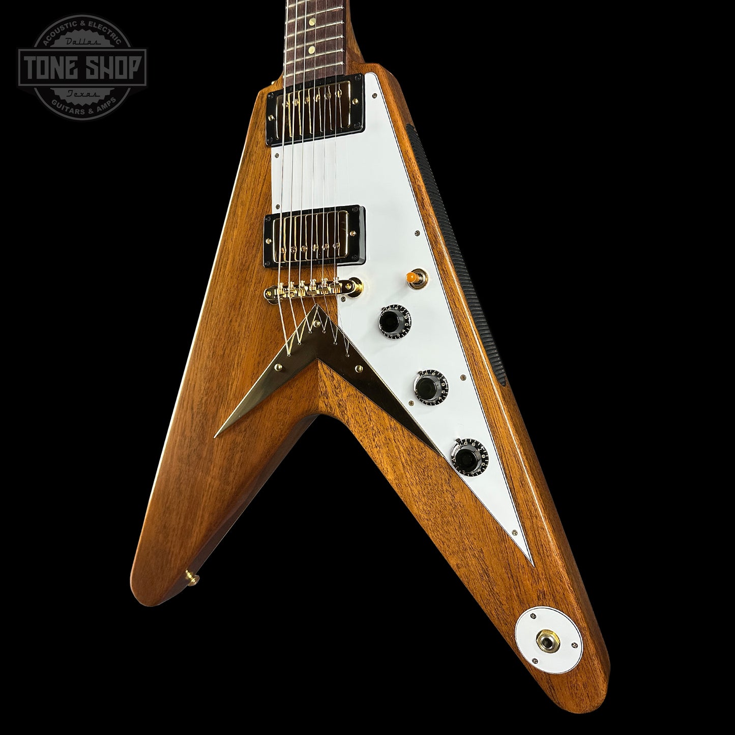 Wooden electric guitar with a white pickguard on a black background, featuring the Tone Shop logo.