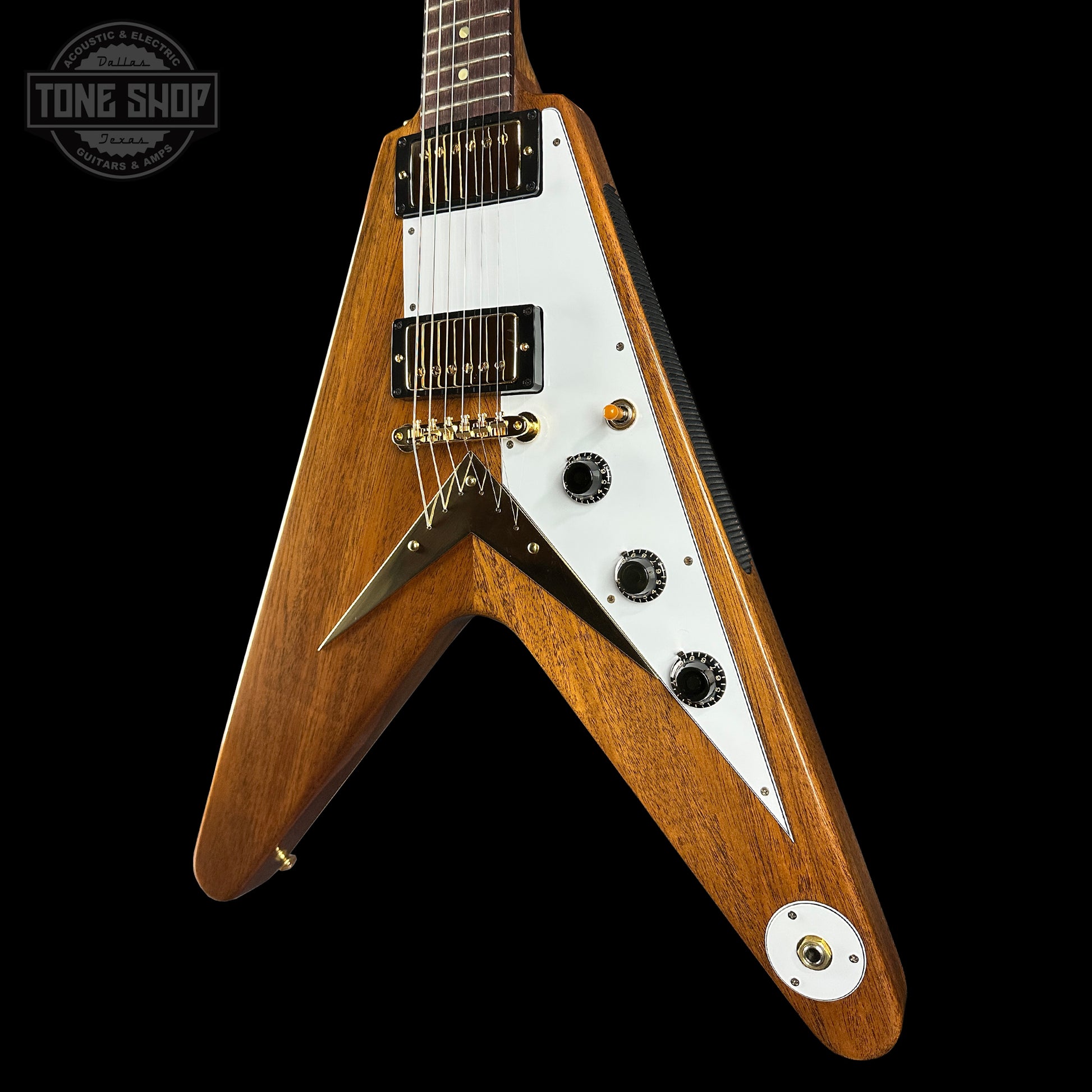 Wooden electric guitar with a white pickguard on a black background, featuring the Tone Shop logo.