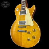 Yellow electric guitar with a 'Tone Shop' logo in the corner