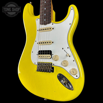 Yellow electric guitar with a white pickguard on a black background, featuring the Tone Shop logo.