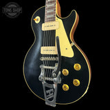 Black and gold electric guitar on a black background with 'Tone Shop' logo.