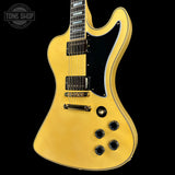 Yellow electric guitar with a black pickguard on a black background, featuring 'Tone Shop' branding.