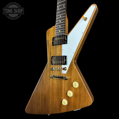 Wooden electric guitar with a white pickguard on a black background, featuring the Tone Shop logo.