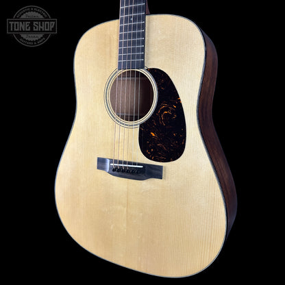 Acoustic guitar with a visible brand logo on a black background