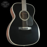 Black acoustic guitar on a black background with 'Tone Shop' logo.