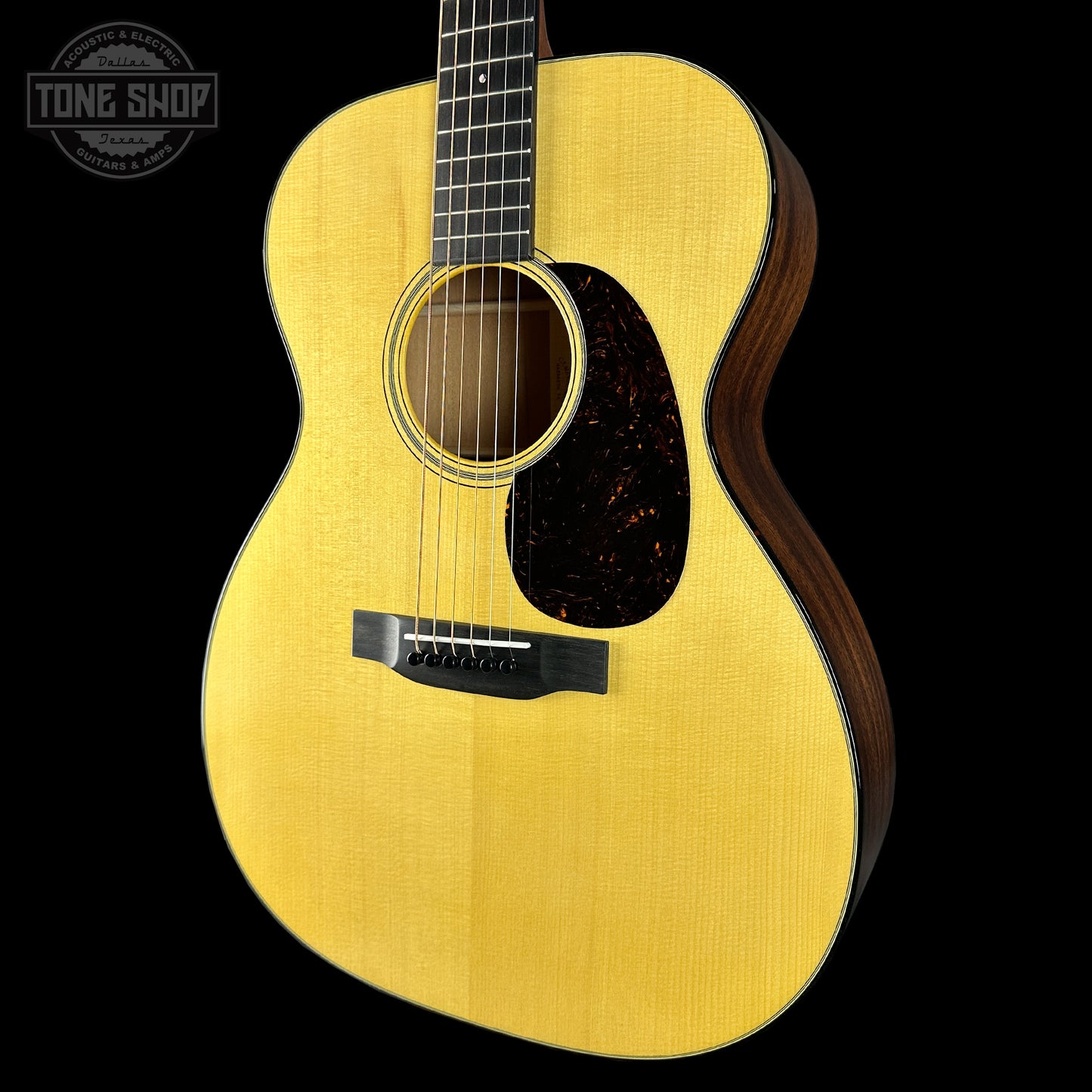 Acoustic guitar with a visible brand logo on a black background