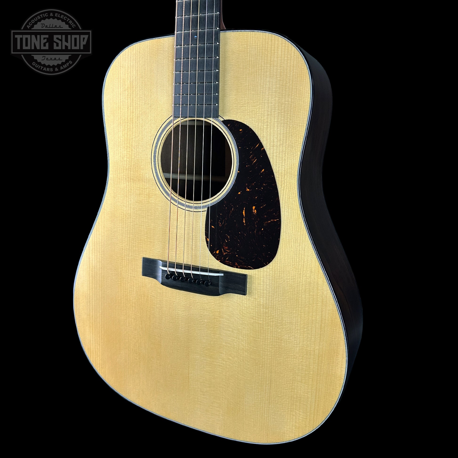 Acoustic guitar with a visible brand logo on a black background