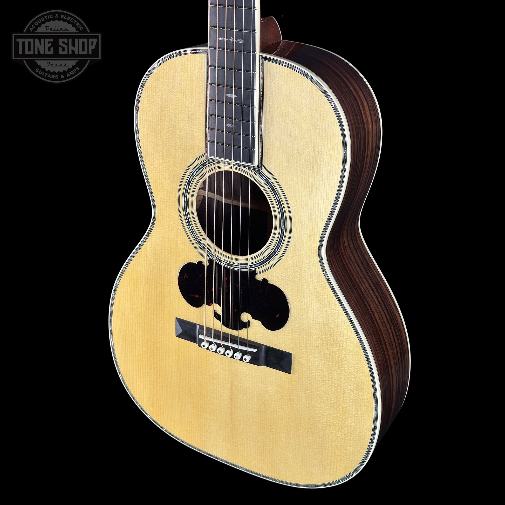 Acoustic guitar with a visible brand logo on a black background