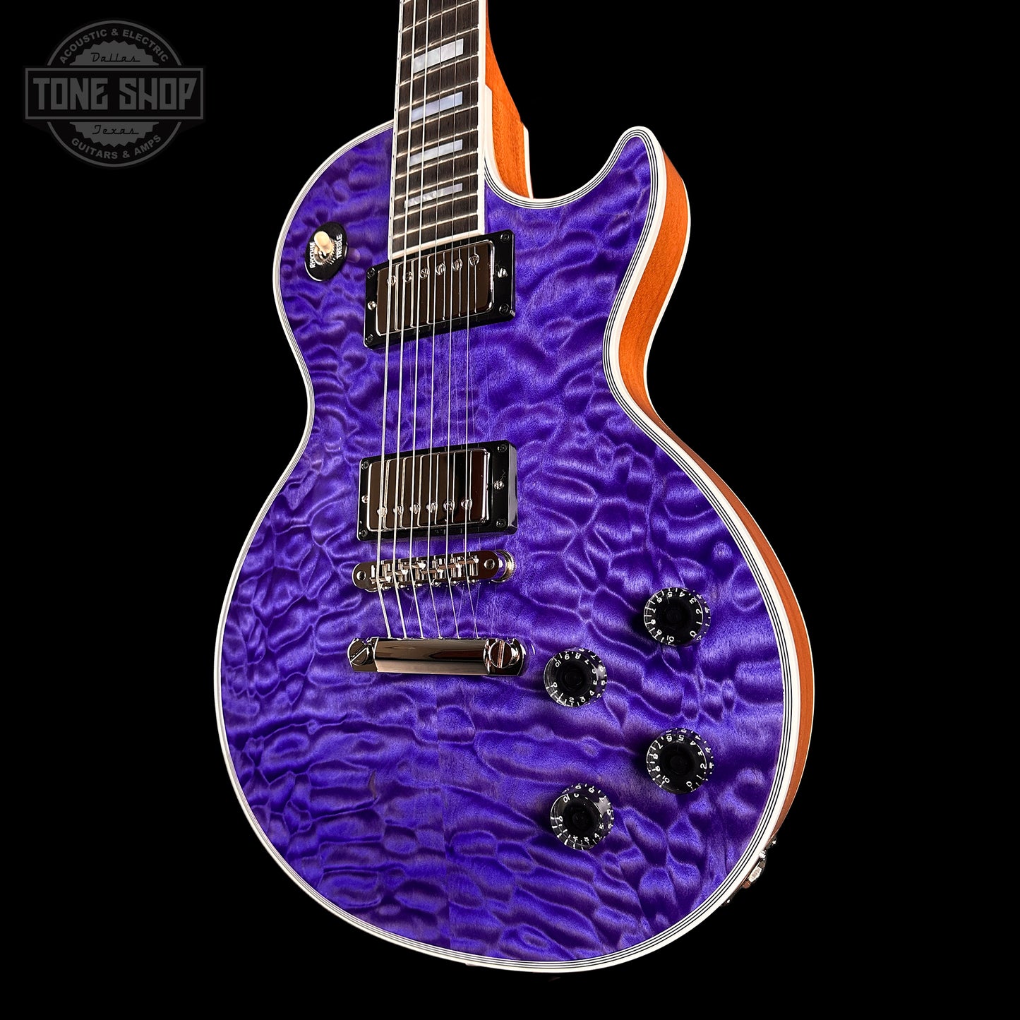 Purple electric guitar with a wavy finish on a black background, featuring 'Tone Shop' branding.