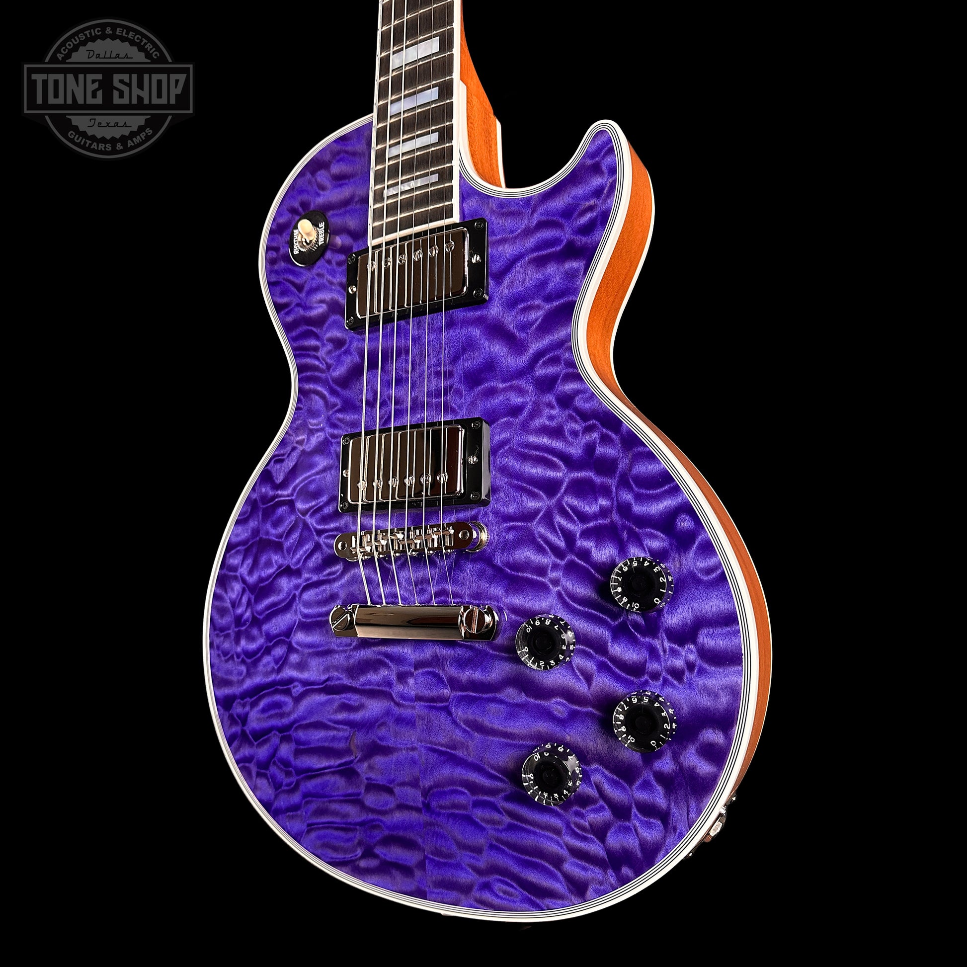 Purple electric guitar with a wavy finish on a black background, featuring 'Tone Shop' branding.