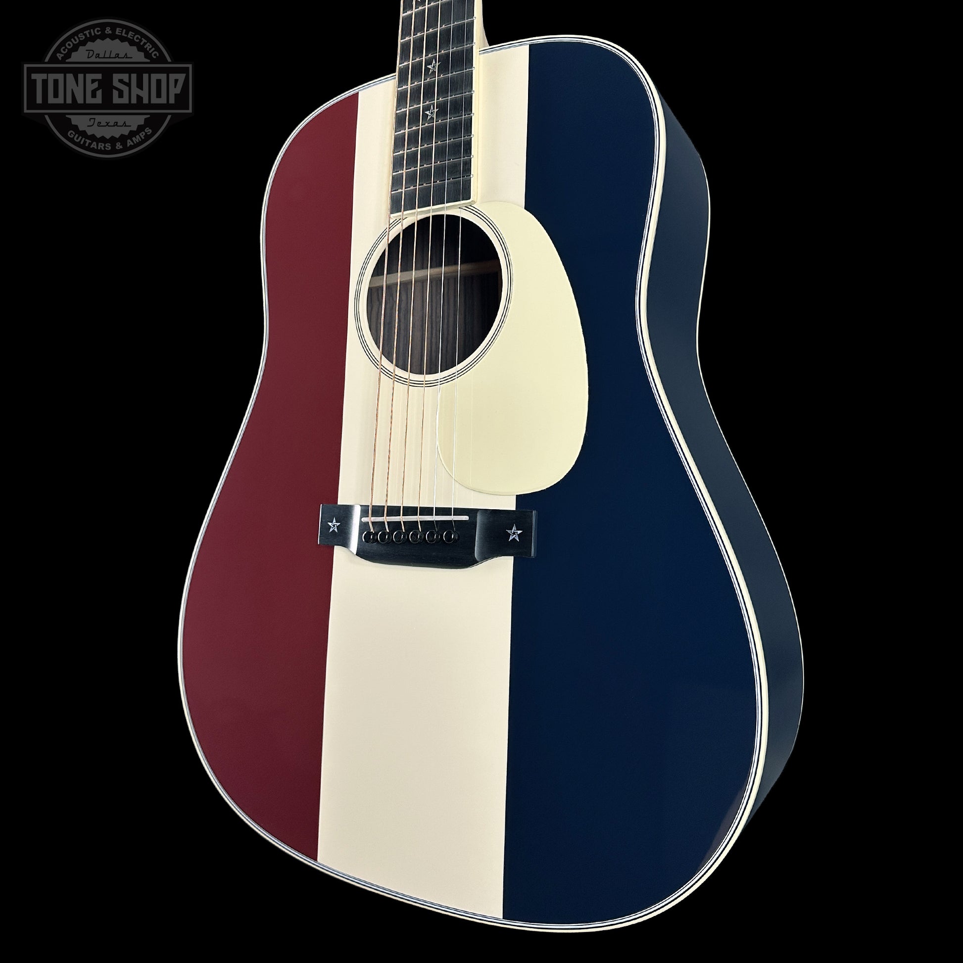 Acoustic guitar with a blue, red, and white striped body on a black background