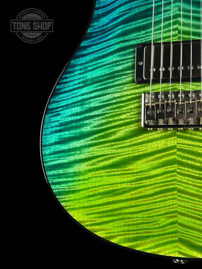 Close-up of a guitar with green and blue striped pattern on a black background