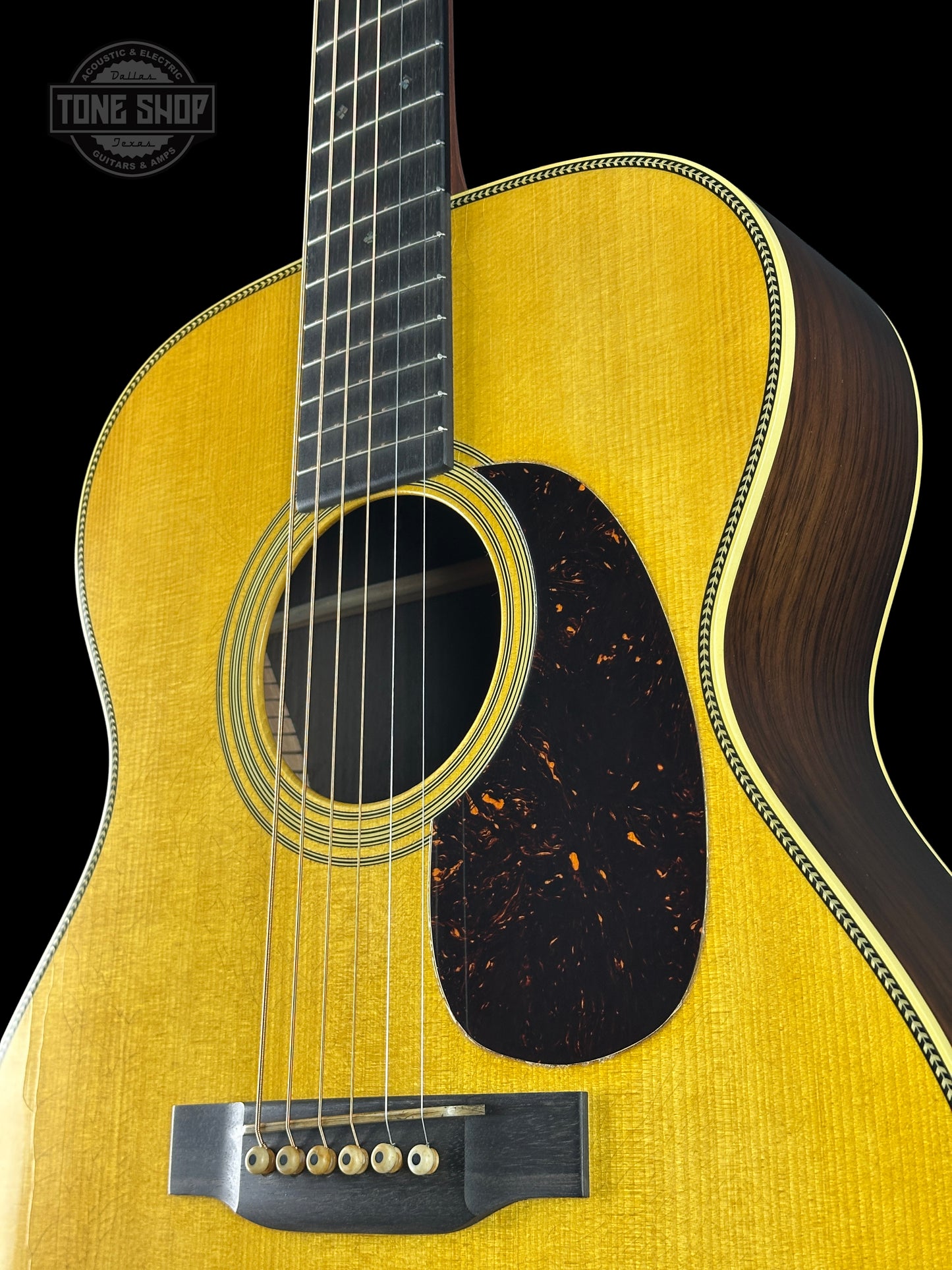 Acoustic guitar with a visible brand logo on a black background