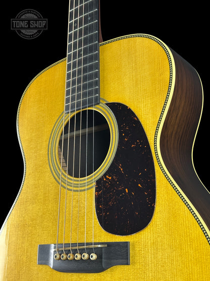 Acoustic guitar with a visible brand logo on a black background