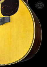 Close-up of a guitar with a visible brand logo on a black background