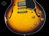 Close-up of a vintage electric guitar with a sunburst finish on a black background.