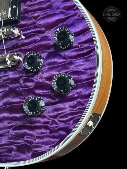 Close-up of a guitar headstock with purple pickguard and visible brand logo.