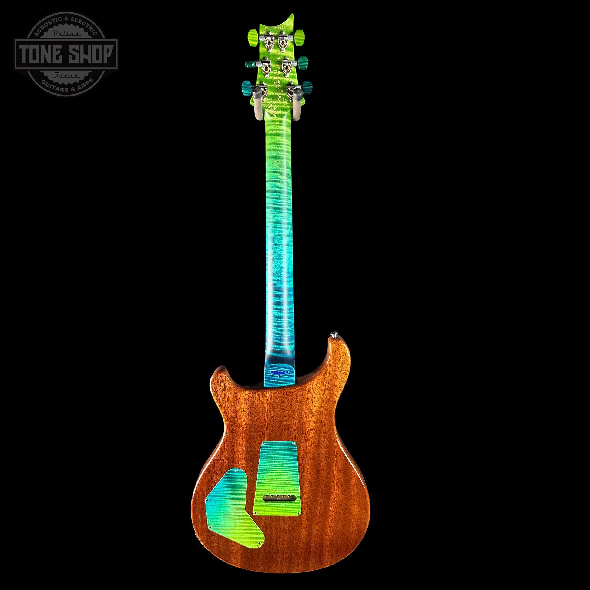 Guitar with a multicolored neck and wooden body on a black background, featuring 'Tone Shop' logo.