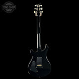 Black electric guitar on a white background with 'Tone Shop' logo.