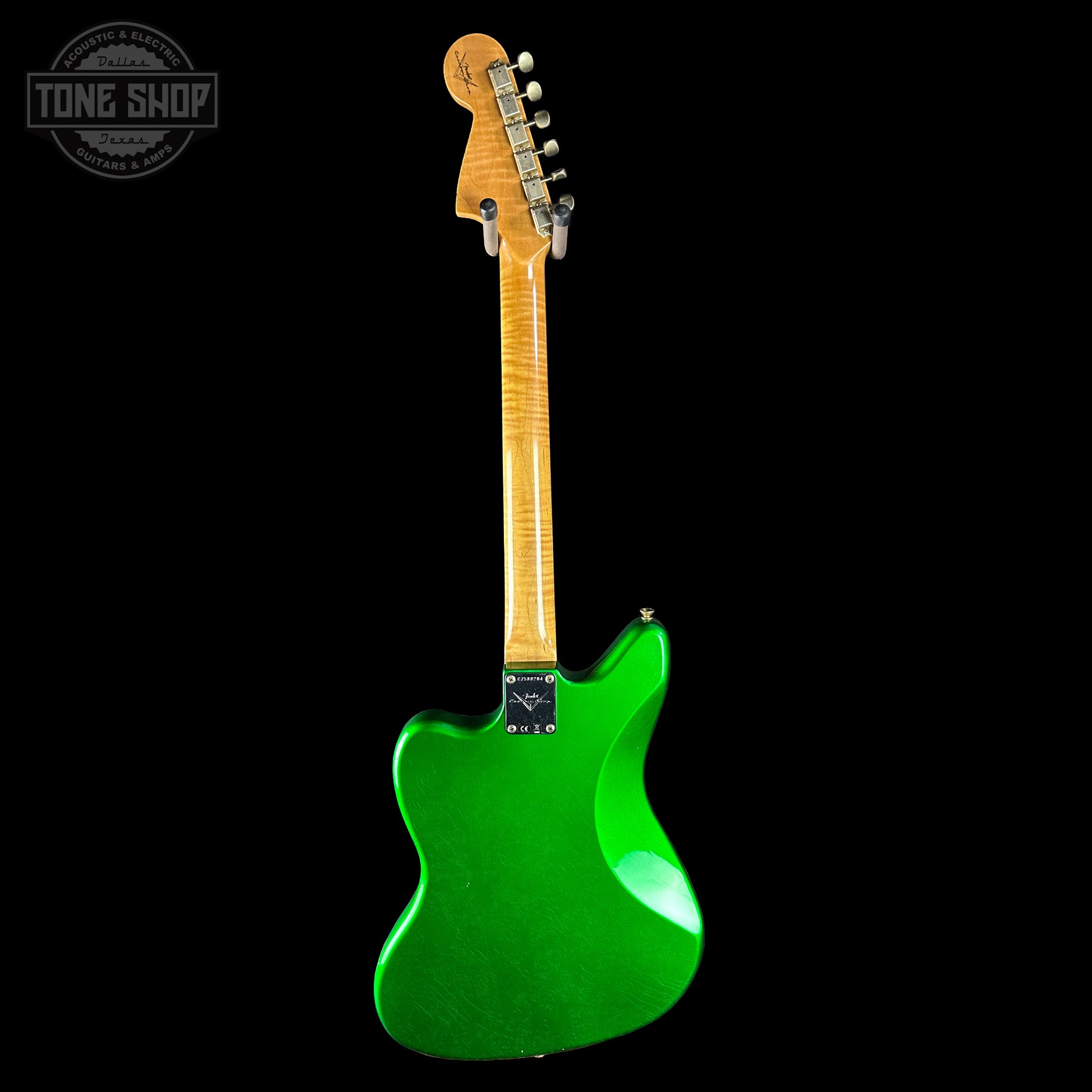 Green electric guitar with a wooden neck on a black background, featuring 'Tone Shop' logo.