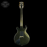Black electric guitar with a glittery finish on a white background, featuring 'Tone Shop' branding.