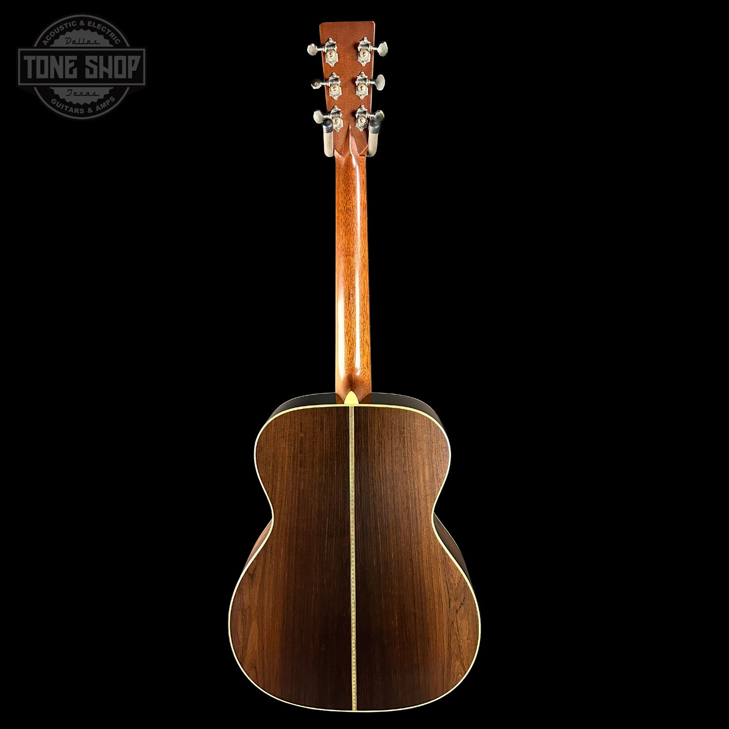 Back view of a wooden acoustic guitar with 'Tone Shop' logo in the corner.