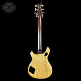Back view of a wooden electric guitar on a black background with 'Tone Shop' logo.