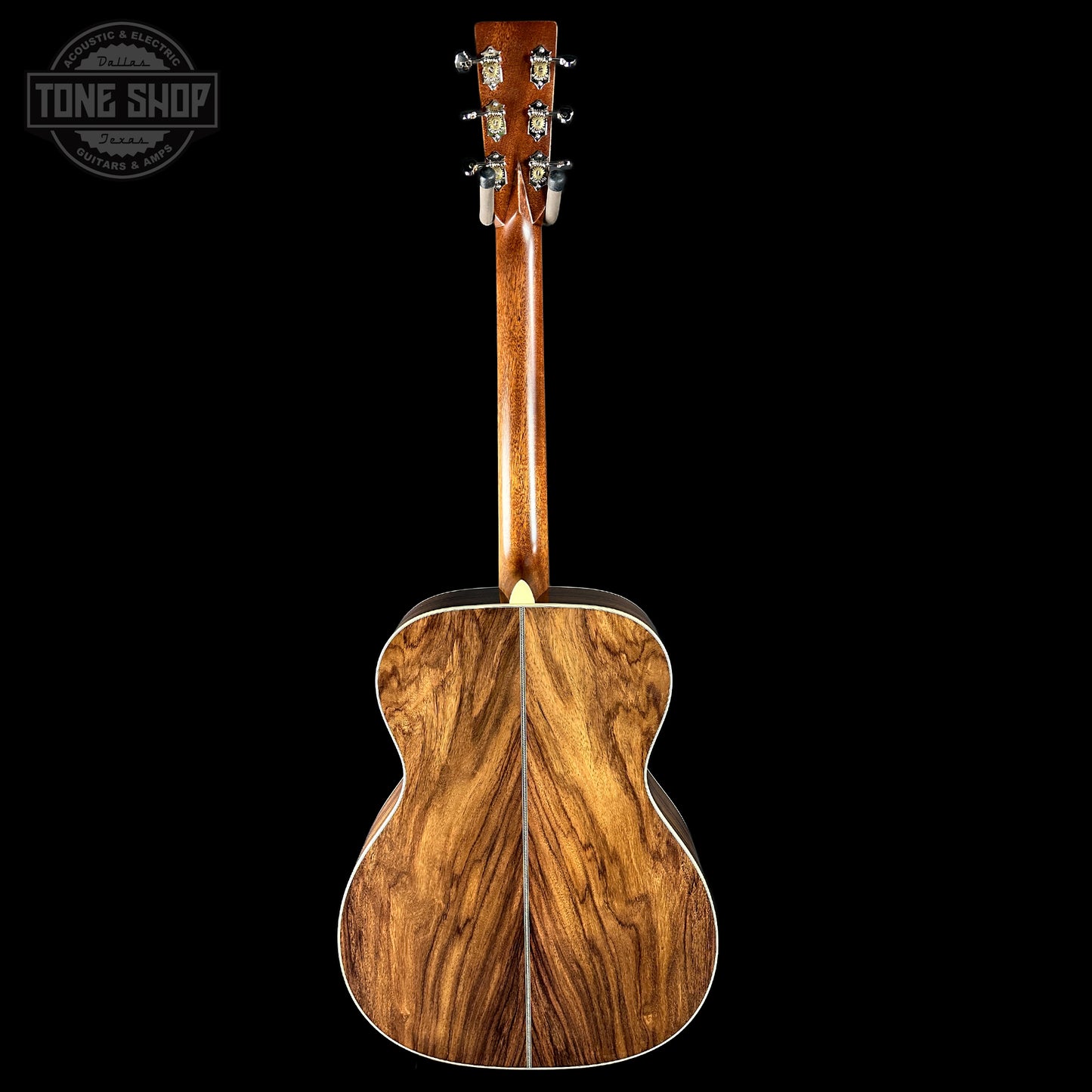 Back view of a wooden acoustic guitar with 'Tone Shop' logo in the corner.