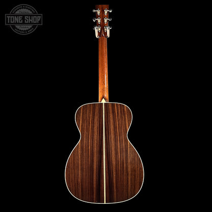 Back view of a wooden acoustic guitar with 'Tone Shop' logo in the corner.