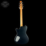 Black electric guitar with a maple neck on a black background, featuring 'Tone Shop' branding.