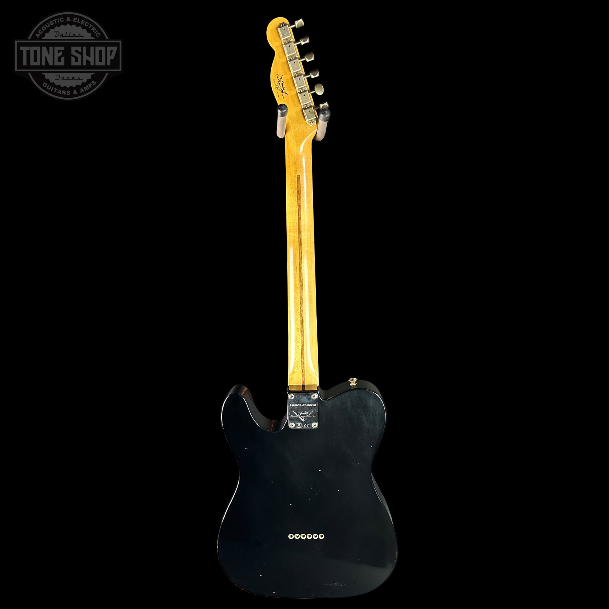 Back view of a black electric guitar with a visible brand logo in the corner.