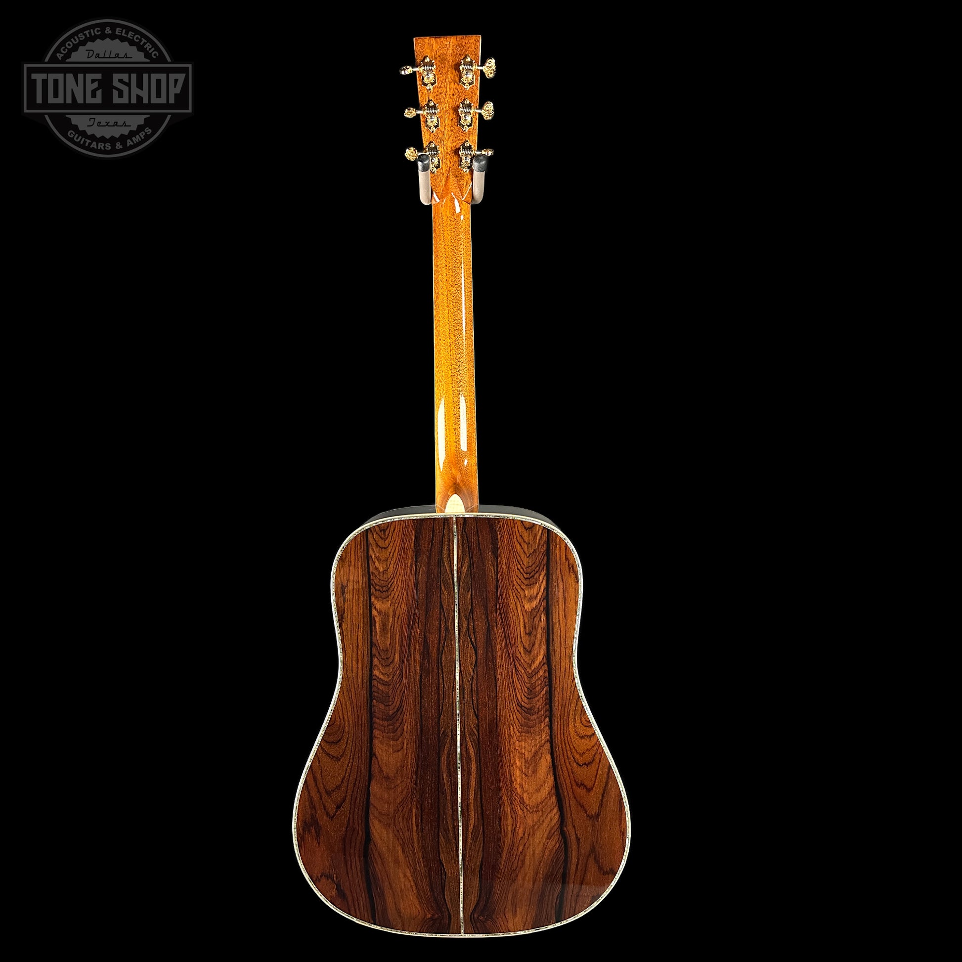 Acoustic guitar with a wooden finish on a black background, featuring the Tone Shop logo.