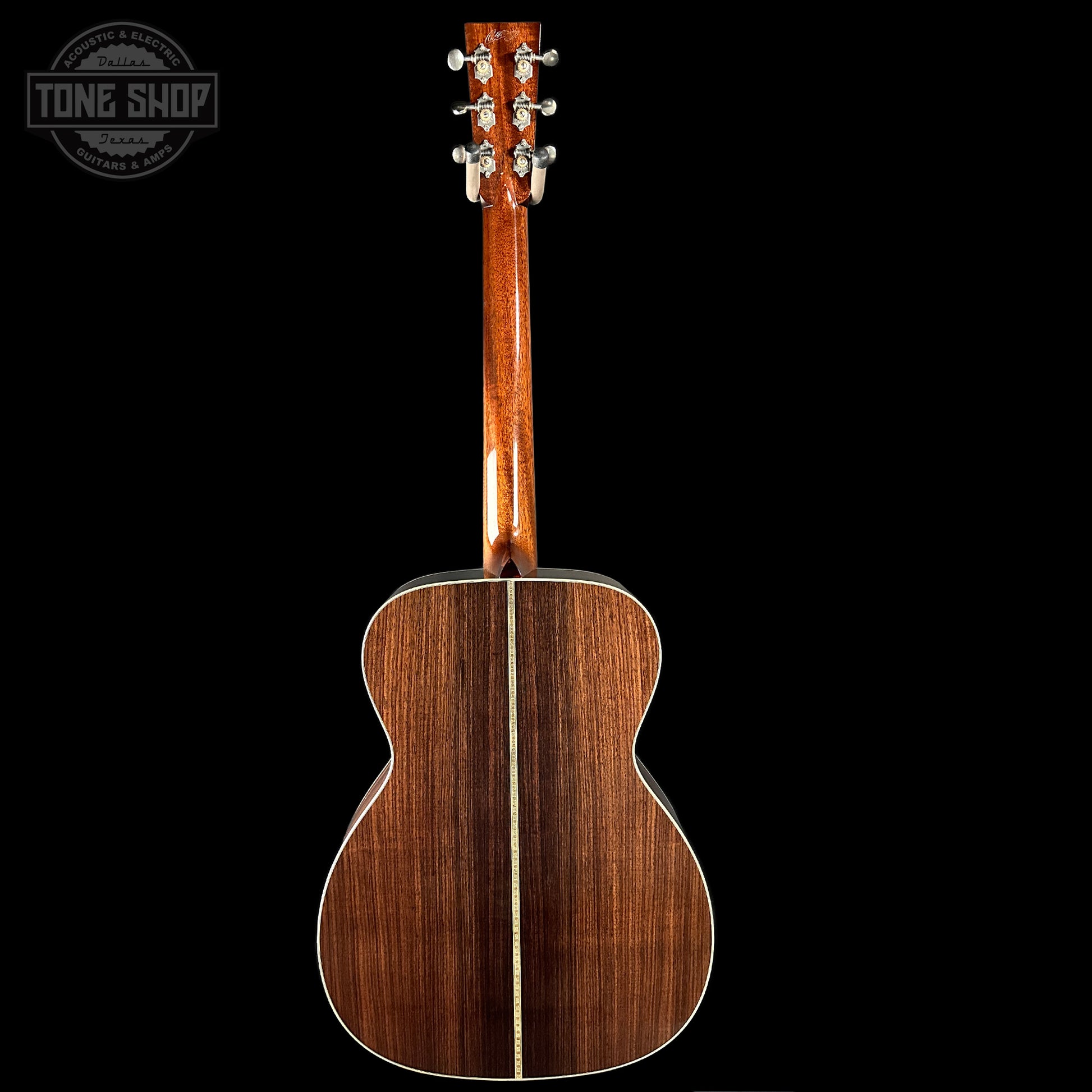 Back view of a wooden acoustic guitar with 'Tone Shop' logo in the corner.