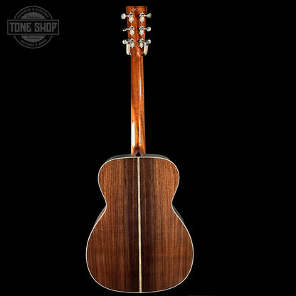 Back view of a wooden acoustic guitar with 'Tone Shop' logo in the corner.