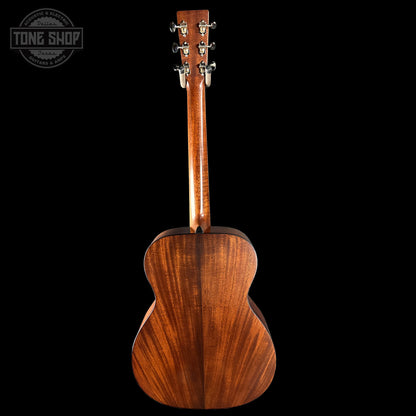 Back view of a wooden acoustic guitar with 'Tone Shop' logo.