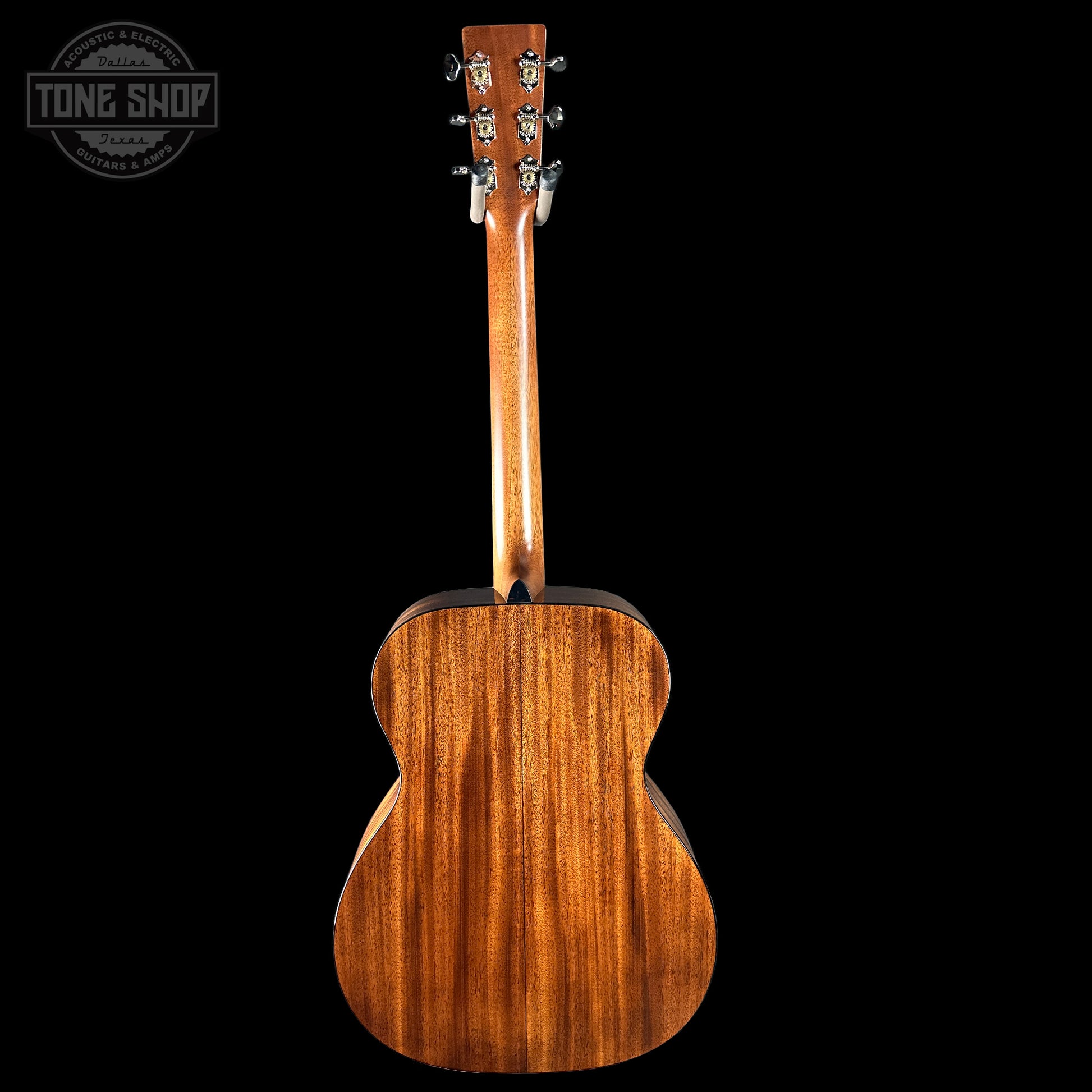 Back view of a wooden acoustic guitar with 'Tone Shop' logo in the corner.