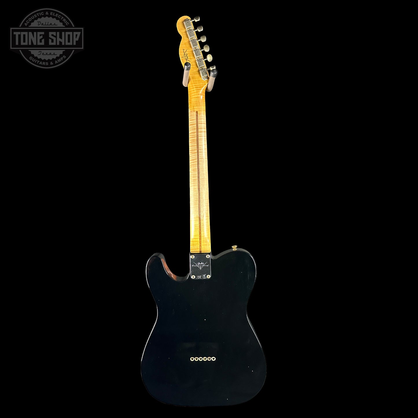 Black electric guitar with a visible brand logo on a black background