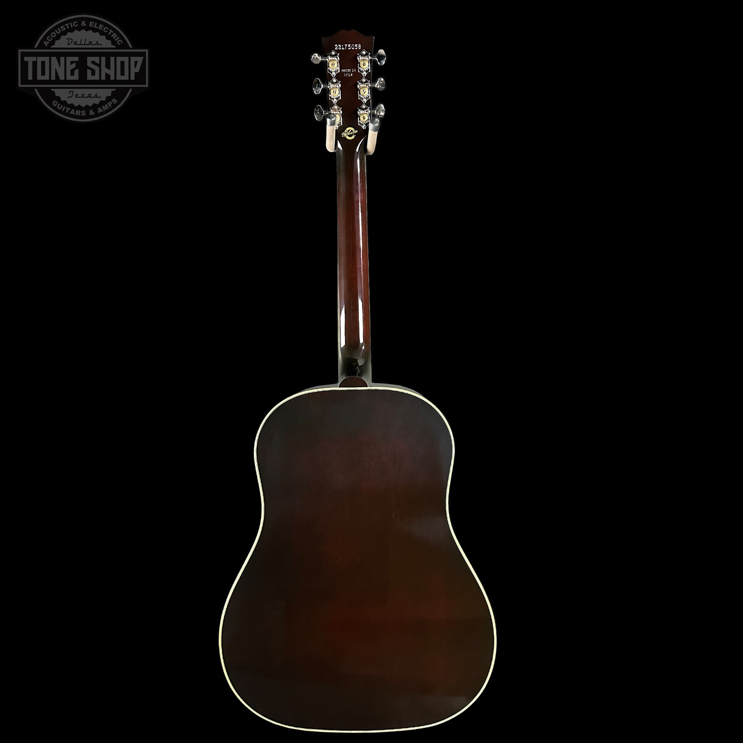 Acoustic guitar with a dark brown finish on a black background, featuring the Tone Shop logo.