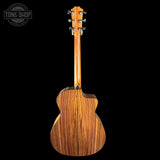 Back view of a wooden acoustic guitar with 'Tone Shop' logo in the corner.