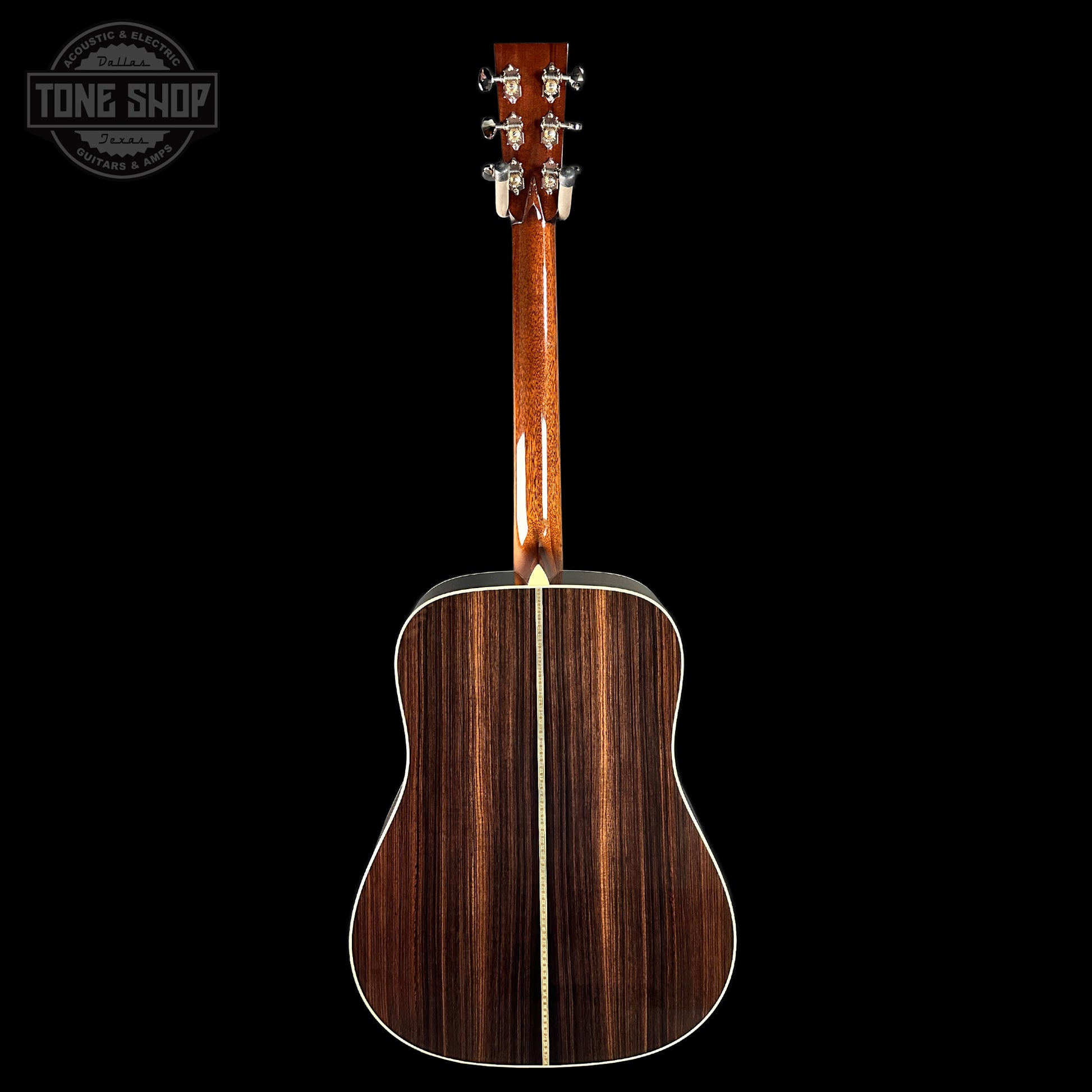Acoustic guitar with a dark wood finish on a black background, featuring the Tone Shop logo.