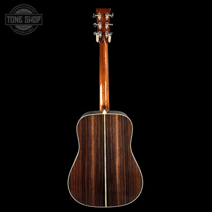 Acoustic guitar with a dark wood finish on a black background, featuring the Tone Shop logo.