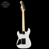 White electric guitar with a black pickguard on a black background, featuring the Tone Shop logo.