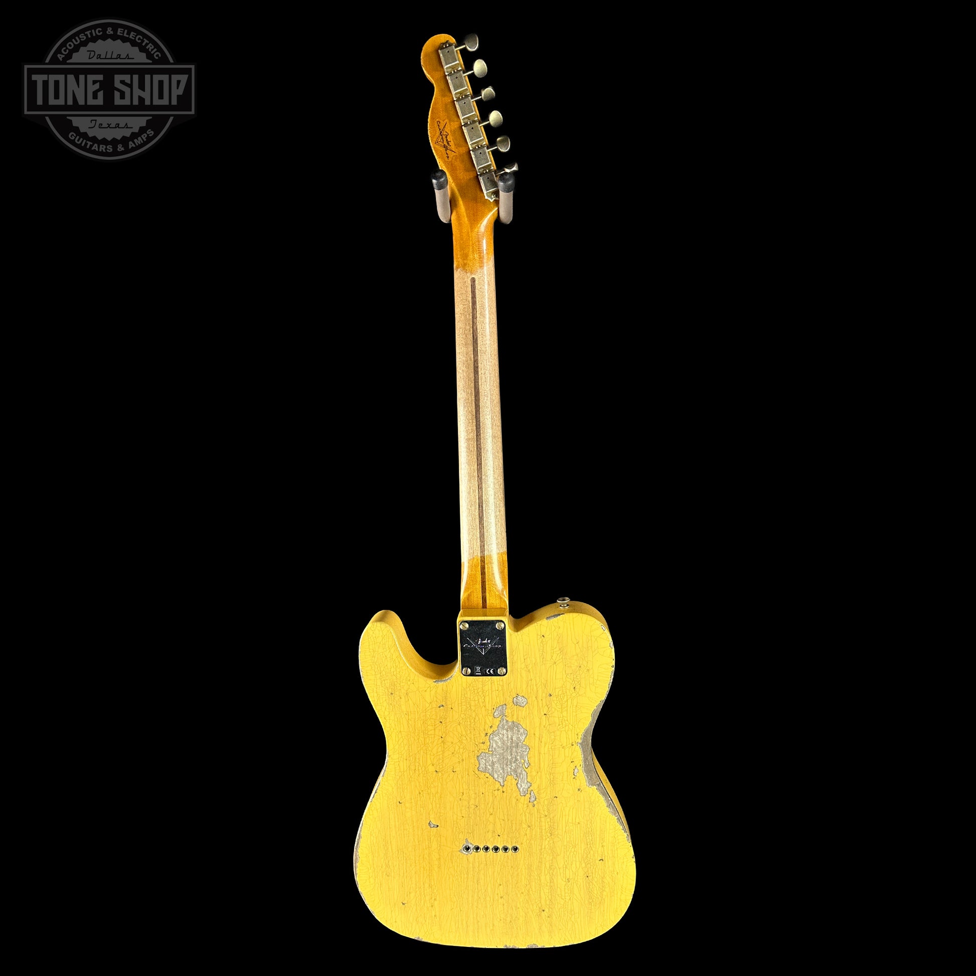 Yellow electric guitar with a visible brand logo on a black background