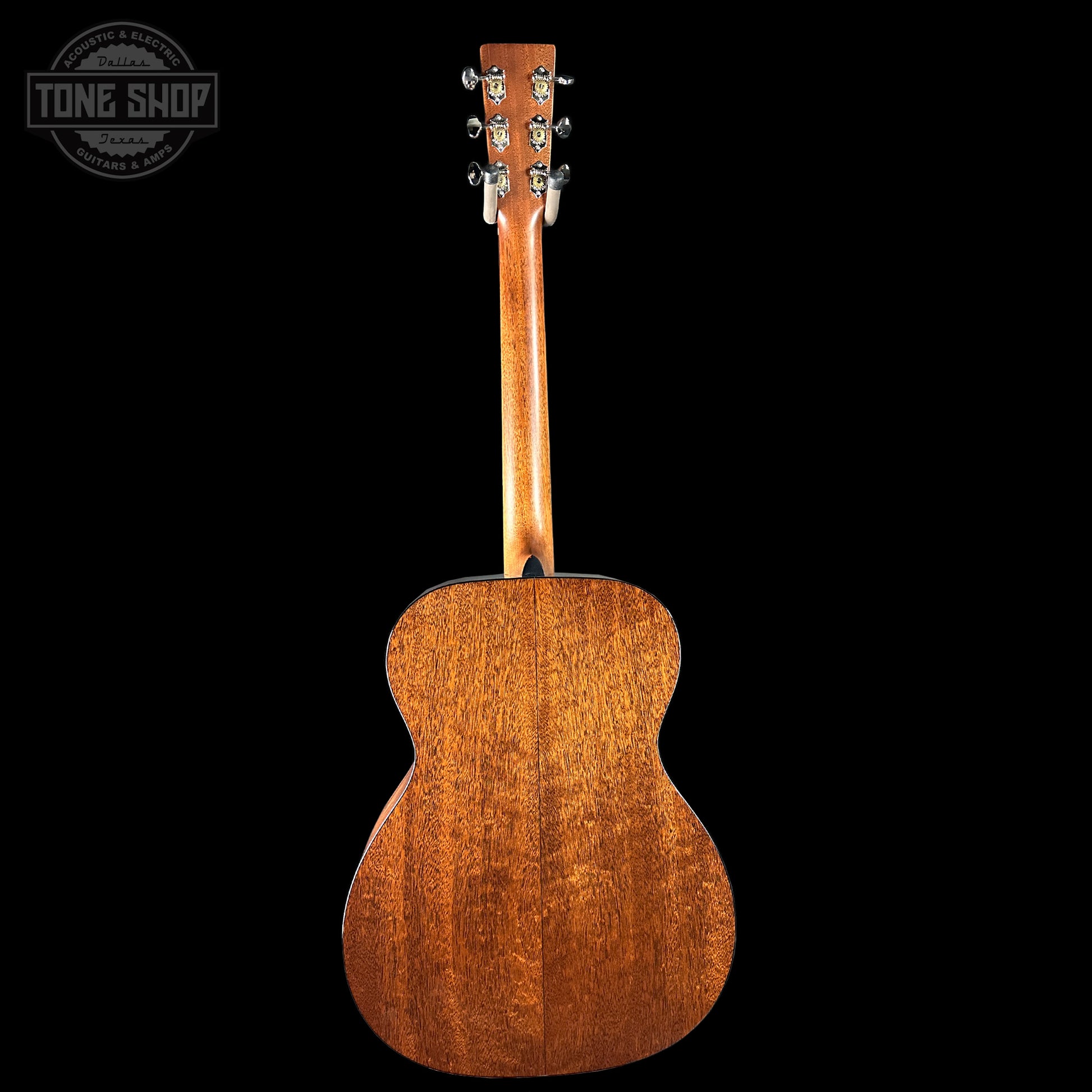 Back view of a wooden acoustic guitar on a black background with 'Tone Shop' logo.