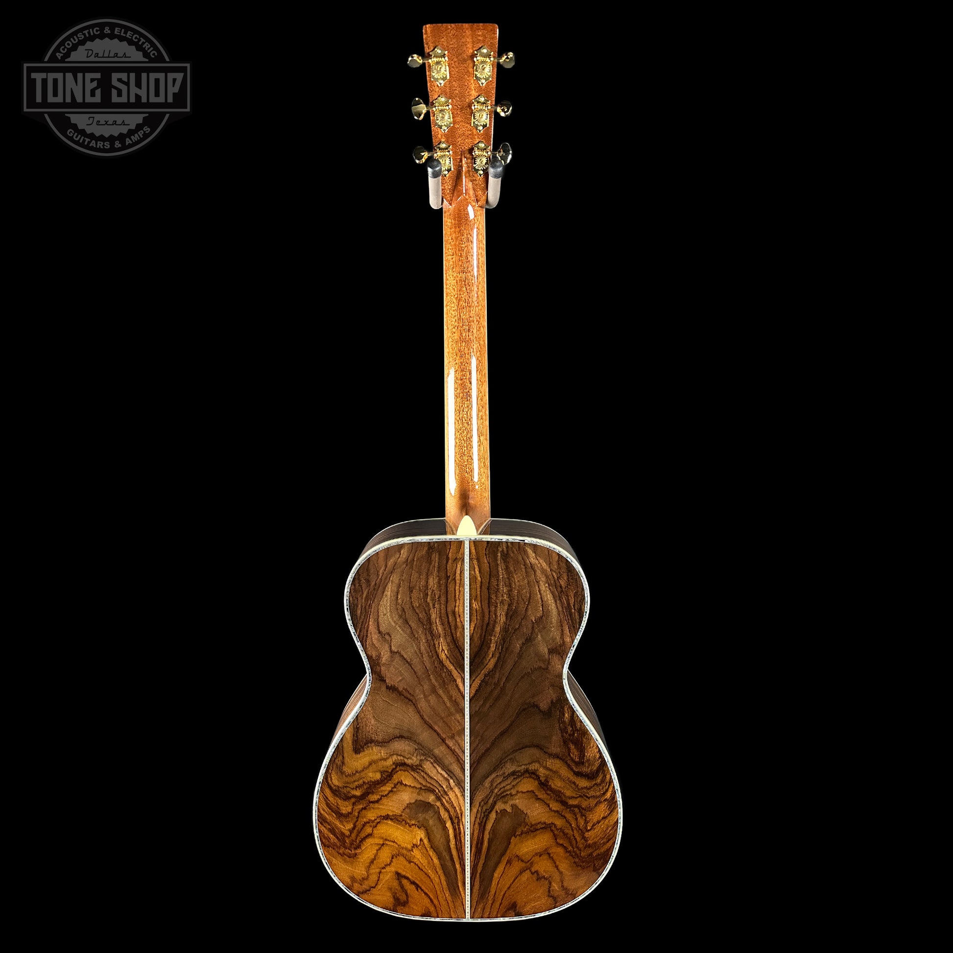 Back view of a wooden acoustic guitar with a visible brand logo in the corner.