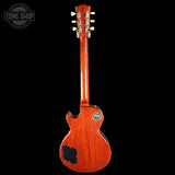 Back view of a red electric guitar with a visible brand logo on a black background.