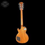 Back view of a wooden electric guitar on a black background with 'Tone Shop' logo.