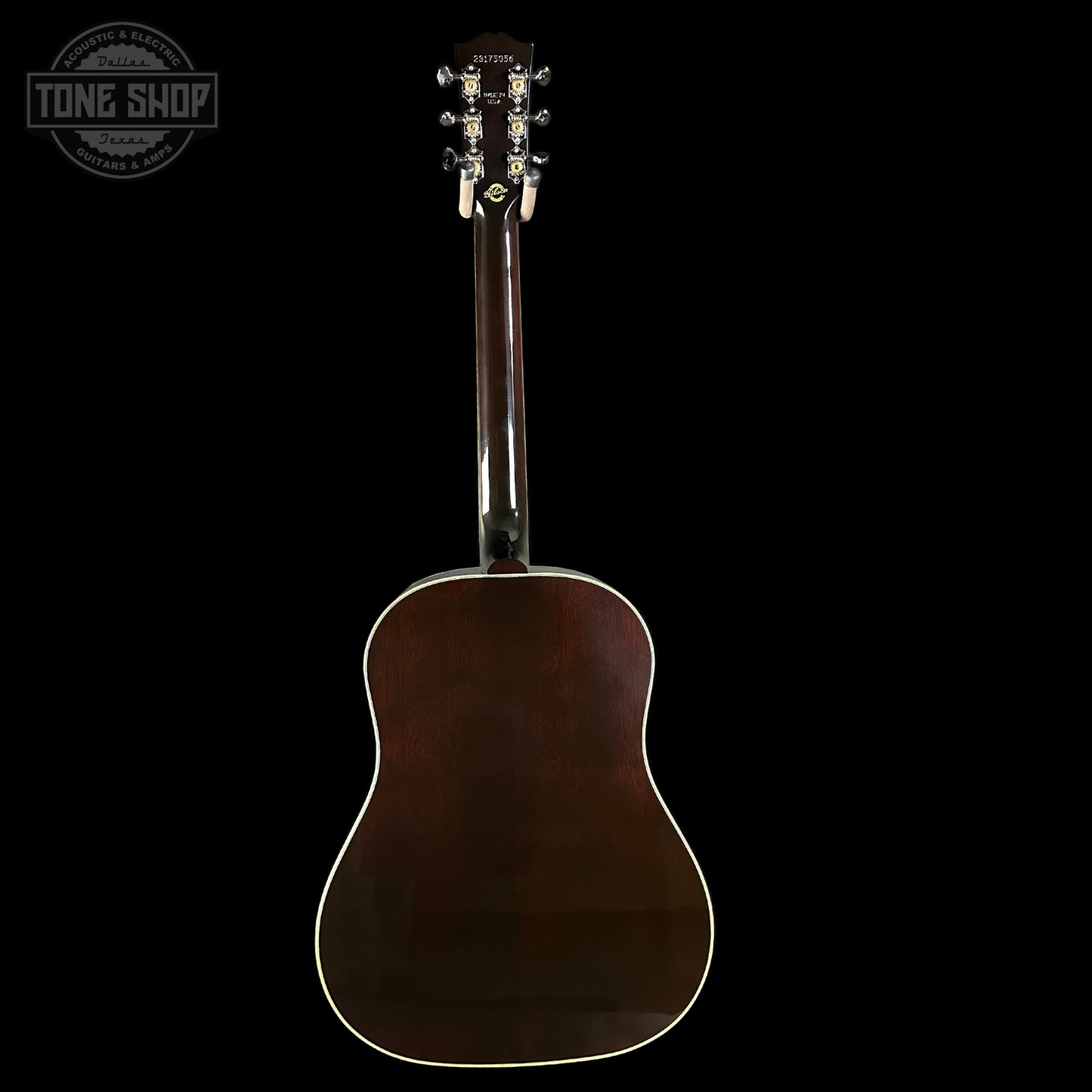Back view of an acoustic guitar with a dark brown finish on a black background, featuring the Tone Shop logo.