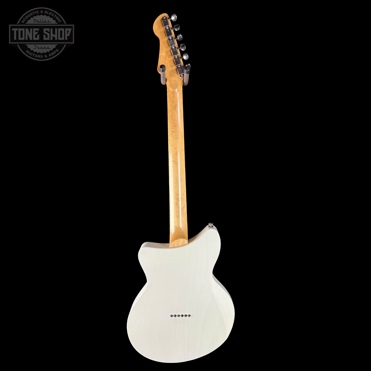 White electric guitar with wooden neck on a black background, featuring 'Tone Shop' logo.
